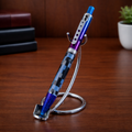 Colorful custom pen with blue and purple accents on a stand, wood desk background