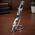 Elegant black and white swirl fountain pen on metal stand, desk background, luxury writing tool