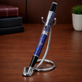 Elegant purple marbled pen on chrome stand, displayed on a wooden office desk