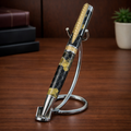 Luxury pen with gold accents and honeycomb pattern on a metal stand, desk background