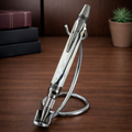 Elegant pearl-accented pen with chrome details on metal stand, desk background