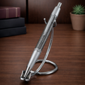Sleek carbon fiber pen with metal accents on a chrome stand, on wooden desk