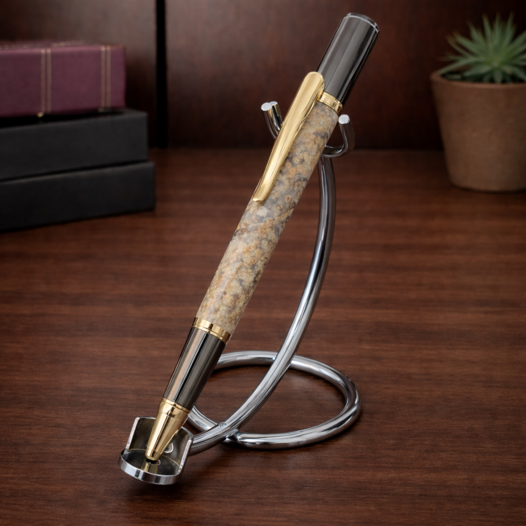Luxury ballpoint pen with gold accents on a metal stand, wooden desk background
