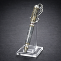 Luxury steampunk-inspired pen with metallic details and honeycomb pattern on acrylic stand