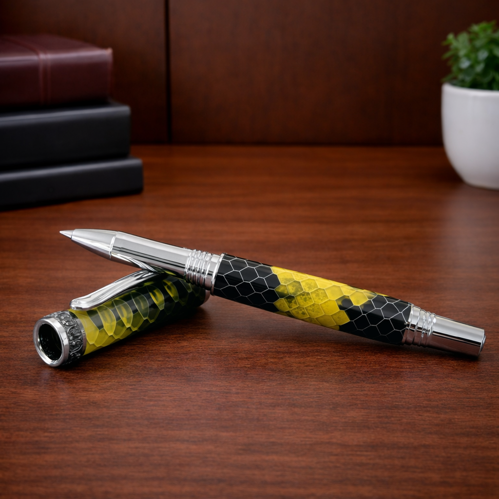 Luxury pen with silver accents and yellow-black honeycomb pattern on wooden desk